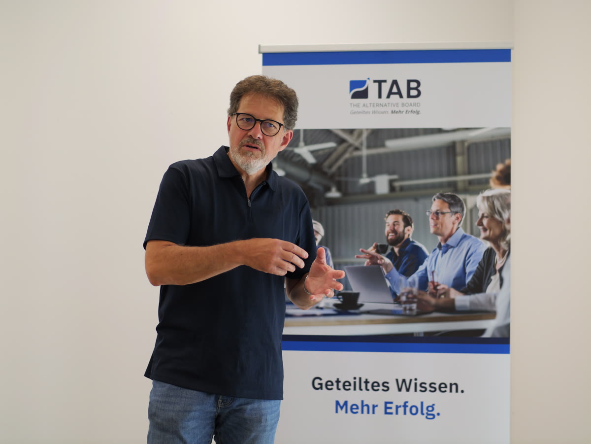 HI-MAP Trainer erklärt vor dem TAB-Banner ein Führungsthema